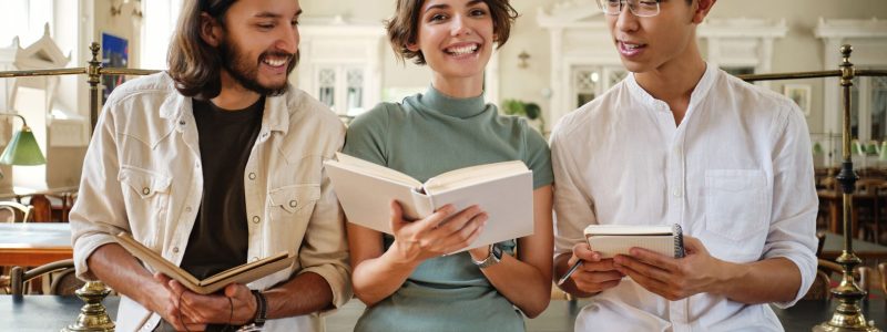 group-young-casual-multinational-students-joyfully-studying-with-book-making-notes-together-library-university (1) (1)