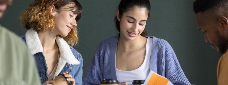 young-man-showing-his-friends-his-notes-study-session (1)